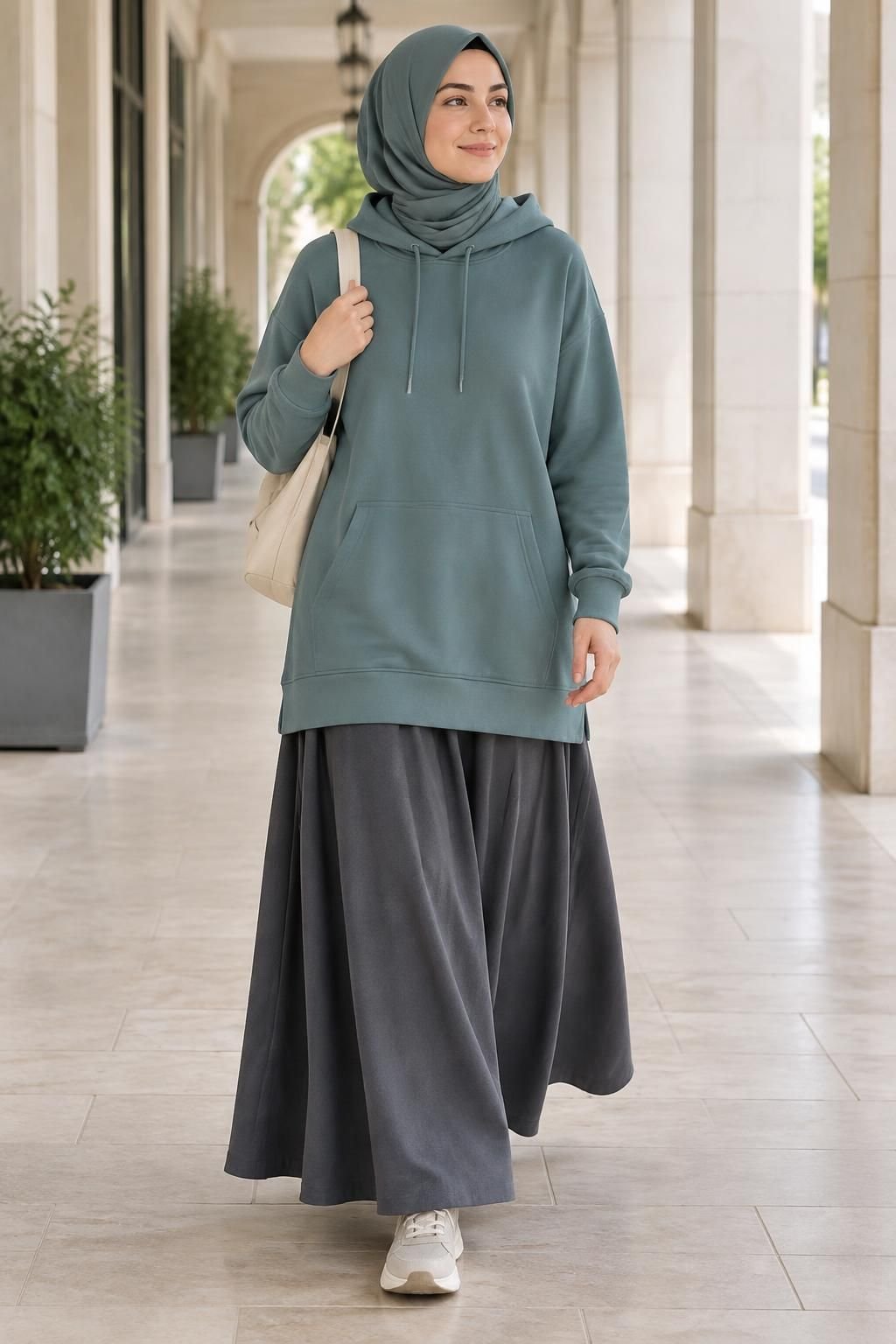 Long muted-teal hoodie with a full charcoal maxi skirt and comfortable sneakers.