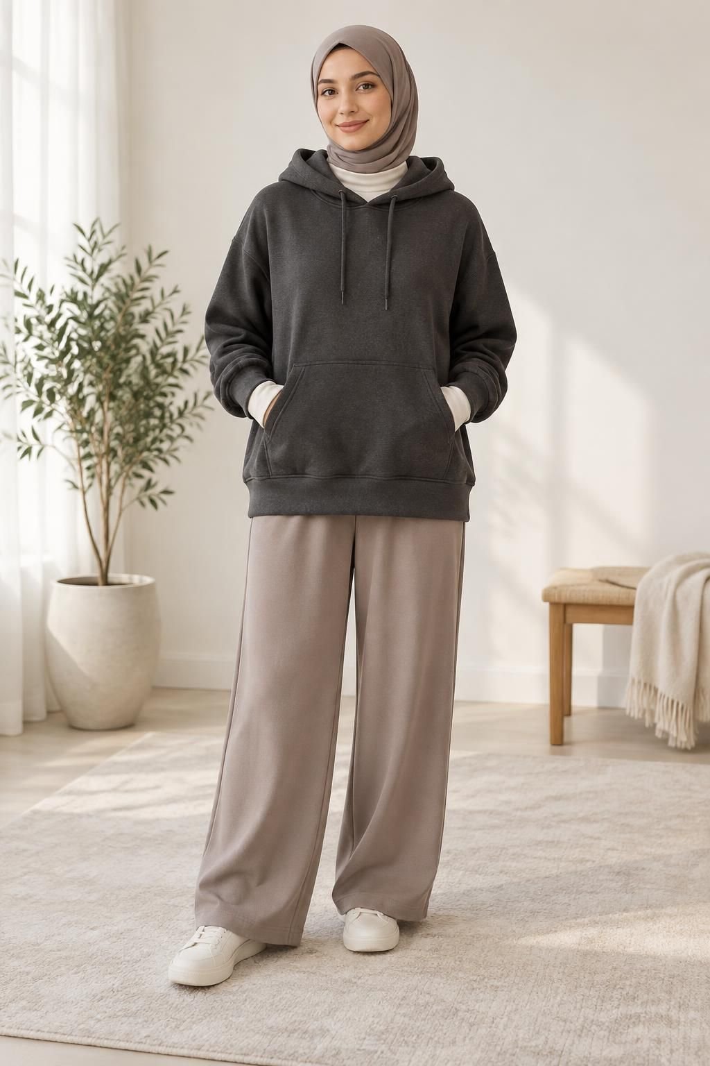 Charcoal hoodie over a cream base layer with taupe hijab, wide-leg trousers, and sneakers.